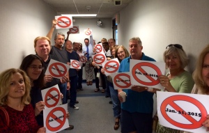 Providence Guild members line the hallway outside a meeting room where a bargaining session regarding GateHouse Media's ownership transition is held. The members, targeted for layoff in early 2015, each hold signs marking his or her individual layoff dates. Most will be losing employment in connection with GateHouse's plan to outsource their jobs to the company's central Design House in Austin, Texas.  